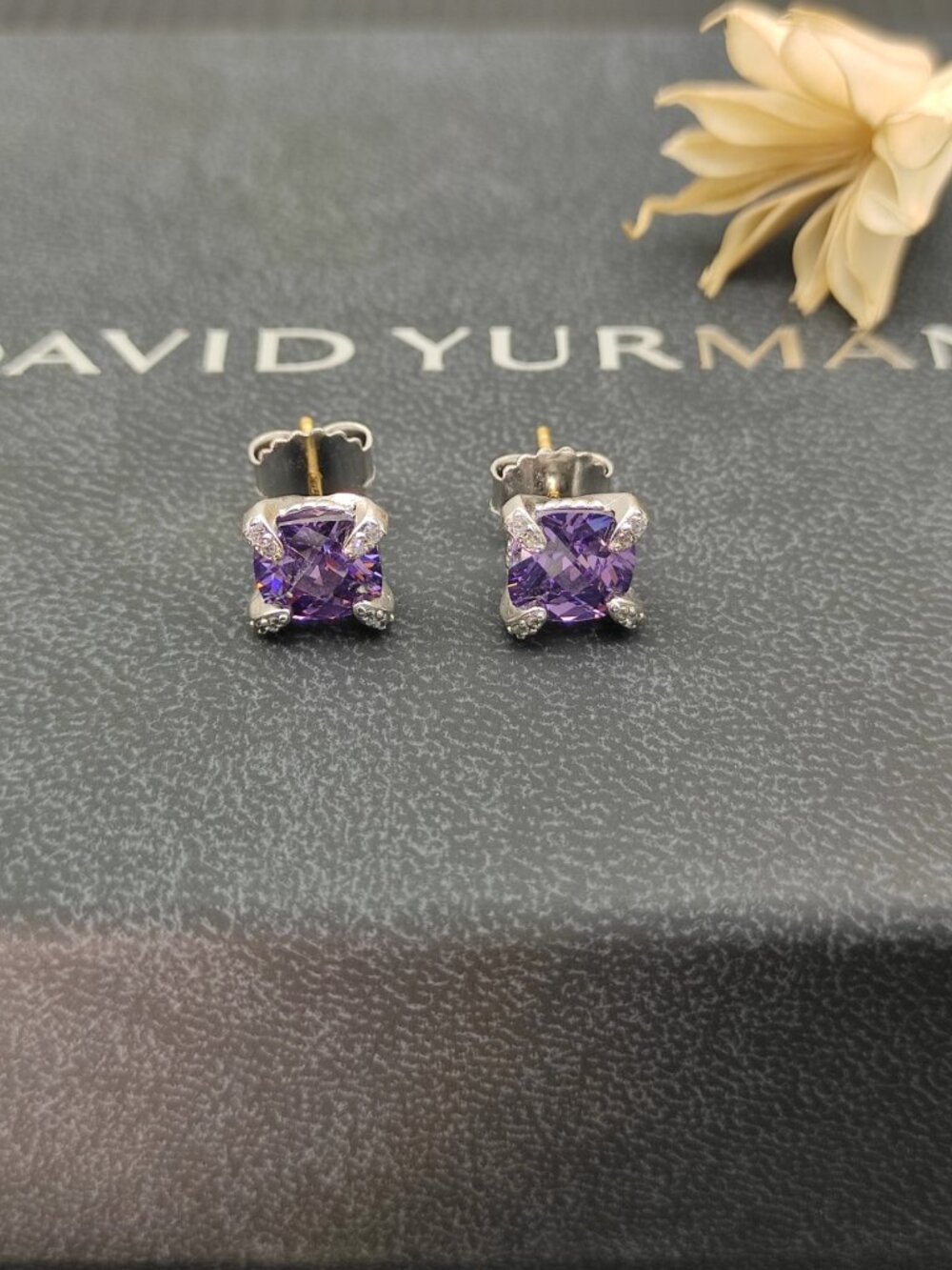 David Yurman four-prong earrings with a main stone and purple diamond.